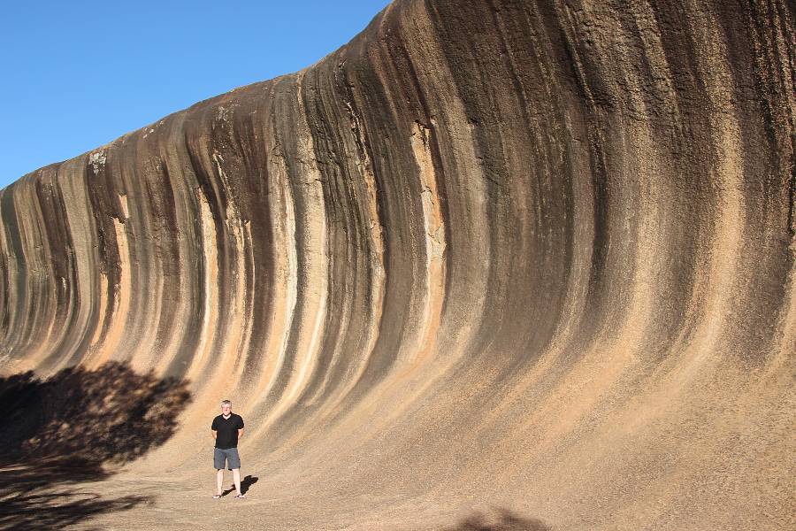 a man standing at Wave Rock in Australia