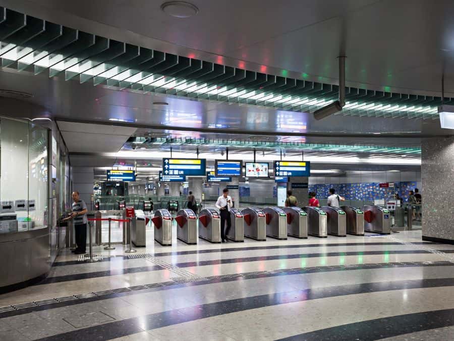 Passengers passing through MRT ticket gates in Singapore.