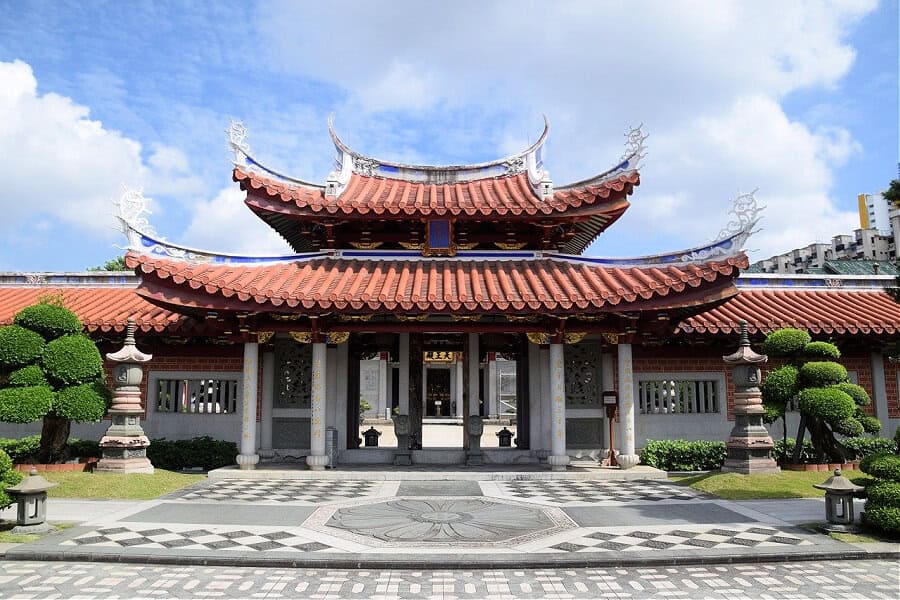 A Chinese Temple in Singapore with a shaped red-tiled roof, and decorated columns – respecting cultural sites as part of the dos and don’ts in Singapore.