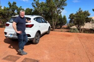 Man standing beside a white car