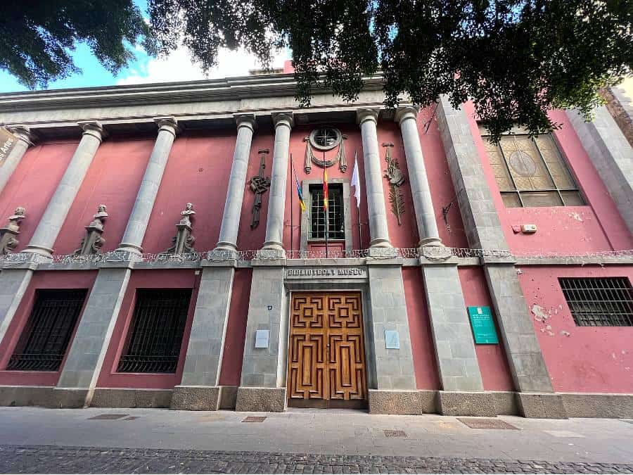 Museo Municipal de Bellas Artes in Santa Cruz de Tenerife with pink facade, columns and wooden entrance doors.