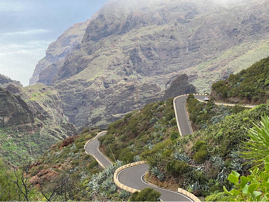 Winding mountain road to Masca in Tenerife with steep ravines and sea views.