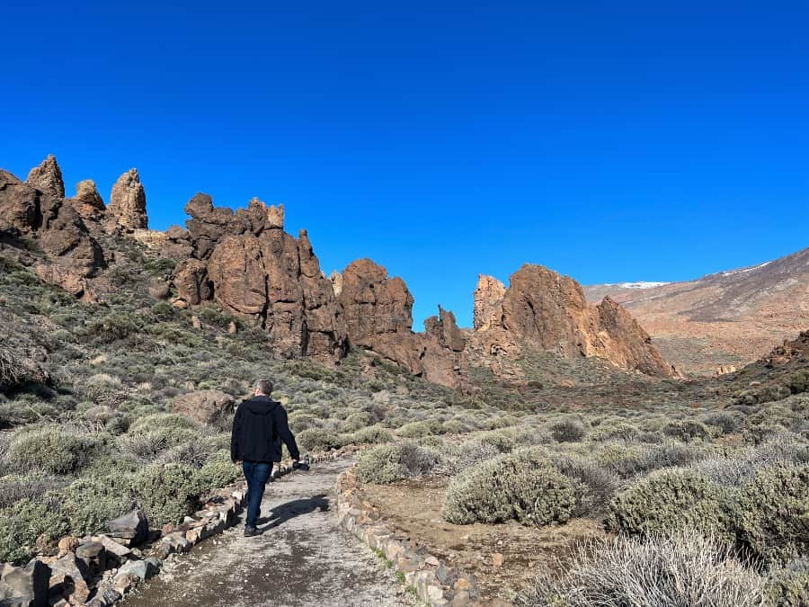 Walking trail through Roques de García in Teide National Park, Tenerife, with volcanic rock formations and Mount Teide scenery.