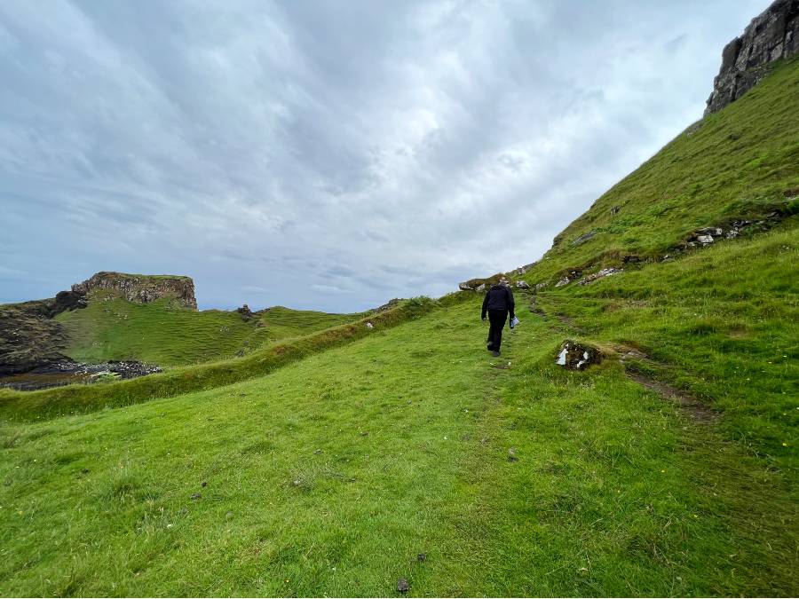 man walking up a grassy bank
