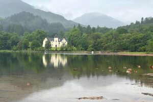 loch shiel and reflections in the water of a house