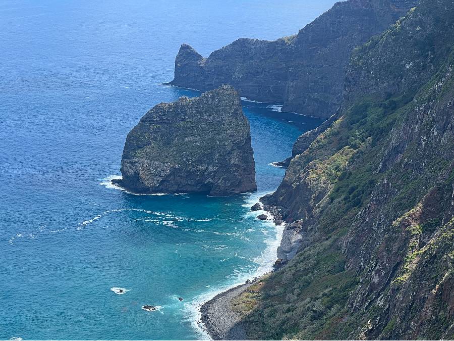 Rocha do Navio cable car descent toward rocky coastal reserve with ocean and green cliffs in the background