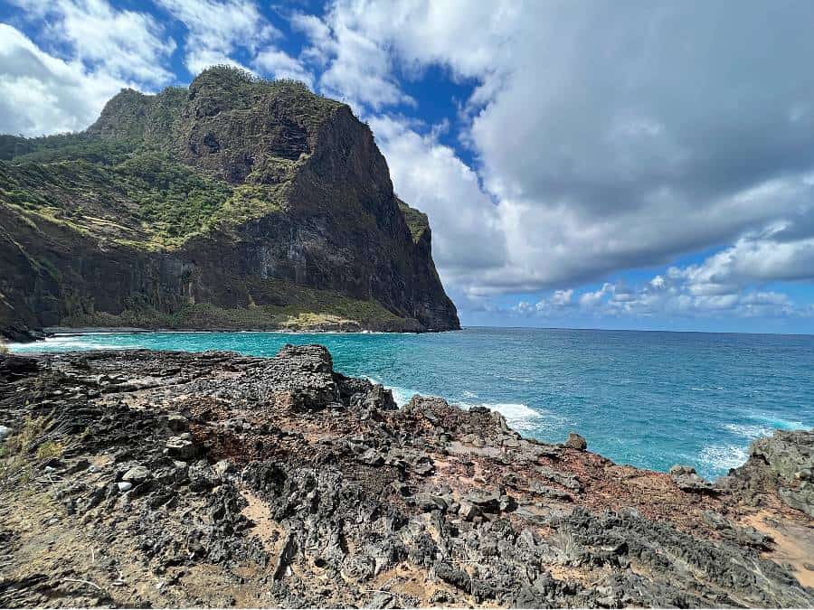 Dramatic volcanic cliffs meet the turquoise Atlantic along the promenade in Porto da Cruz.