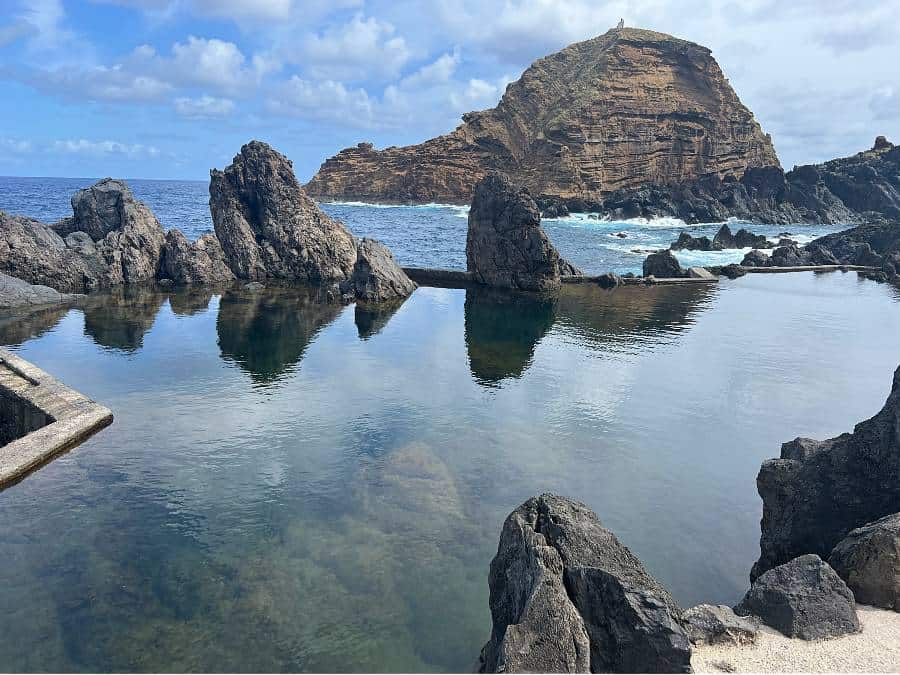 natural pools with rocks and an island in the distance