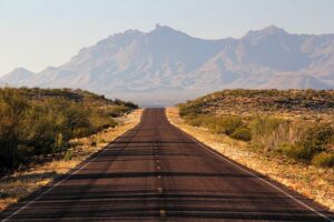 photo of an empty road with mountains in the distance