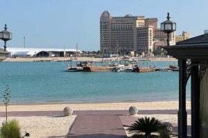 photo of a beach with a large hotel in the distance across the water