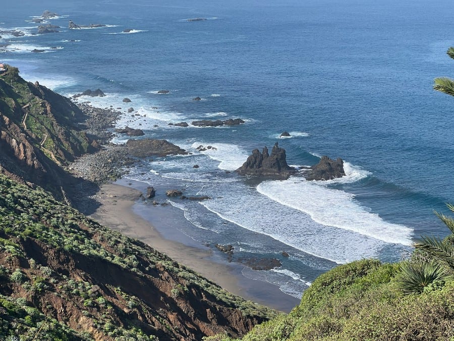 View over Benijo Beach in Tenerife with black sand, rocky coastline, waves and cliffs in Anaga Rural Park.