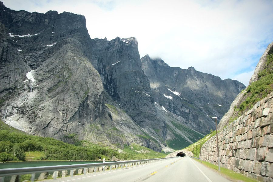 Scenic Norway road trip route through mountains towards a tunnel