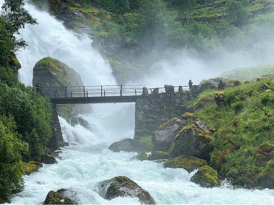 Kleivafossen waterfall spraying across the path to Briksdalsbreen