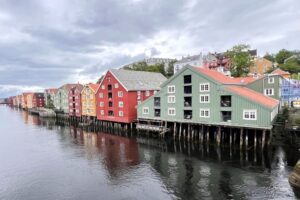 Painted wooden wharves reflected in the Nidelva River in Trondheim